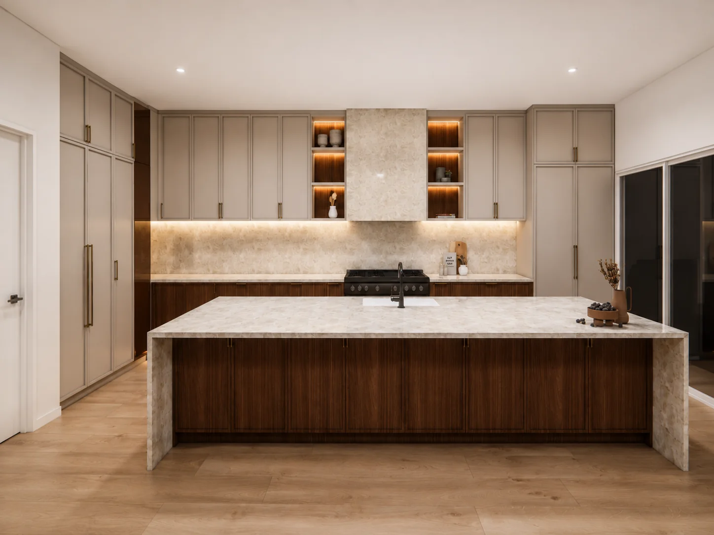 Kitchen island and gas range framed by custom cabinetry